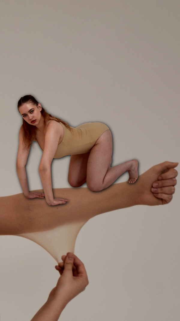 An extended arm clenched in a fist, dressed in a sheer, beige stocking which is being pulled down by another hand, and with a disproportionately small person, wearing a beige leotard, crouching on all fours atop the arm, gazing toward the viewer.