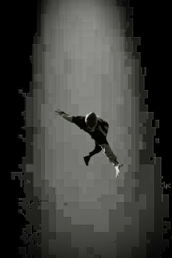 Black-and-white image of a person seen at a distance, falling downward with the body tilted diagonally, one arm reaching up and the other extended down, silhouetted against a vertical column of pixelated light on a black background.
