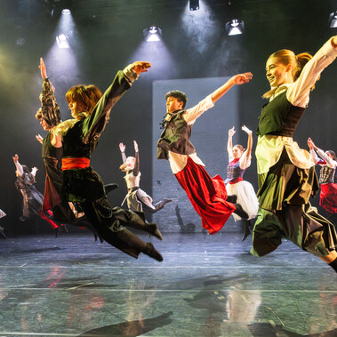 A group of young dancers leap into the air