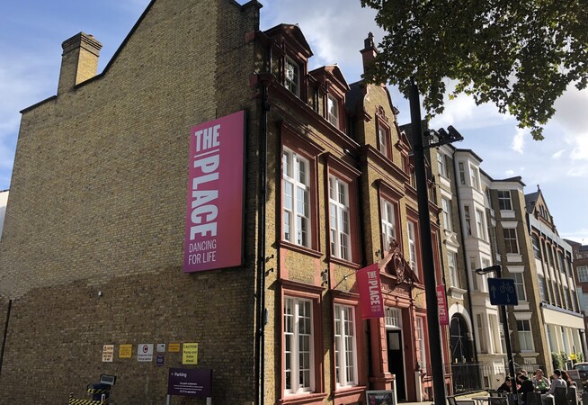 The Place building on Duke's Road from the side with a branded pink banner