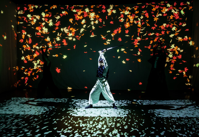 Female swordfighter in front of falling autumn leaves